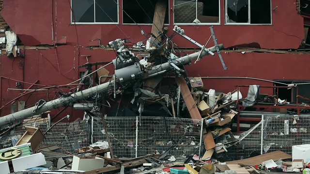 海啸过后的福岛，一根电线杆倒在了一栋建筑上。