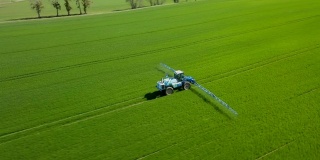 鸟瞰图农用肥料在农田上工作，农业机械在耕地上工作，喷洒农药