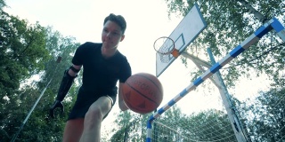 一个年轻人用一个未来派的义肢表演一个篮球的慢动作杂耍