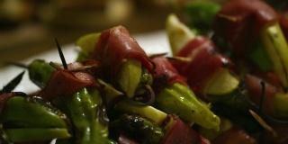 室内庆祝会/派对上的开胃盘上裹着意大利熏火腿的青椒和苹果