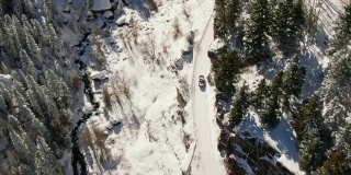 无人机拍摄的一辆卡车在科罗拉多州奥雷市外的圣胡安山脉(落基山脉)的雪道上行驶，周围是一片树林