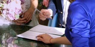 婚礼的传统仪式。婚礼仪式。新婚夫妇签署结婚文件、结婚证。特写镜头