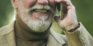 微笑的成熟男人用智能手机聊天，优惠的资费计划，连接