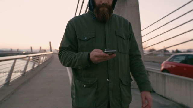 MS Man带着智能手机，在桥上走路发短信