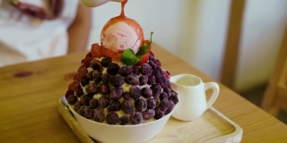 将草莓酱倒入混合水果浆果冰苏或冰苏，韩式刨冰甜点与甜配料
