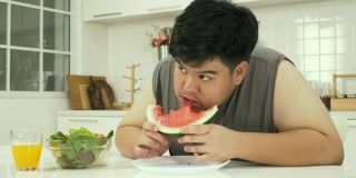 侧面图:泰国超重男子吃西瓜等健康食品时感到饥饿