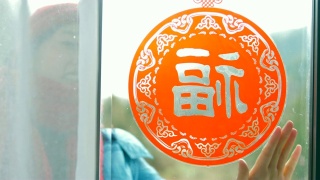妇女把中国传统剪纸贴在窗户上视频素材模板下载