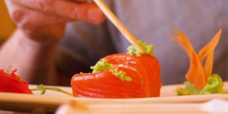 一名男子在传统亚洲餐厅吃日本寿司卷配芥末