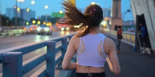 年轻女子慢跑过桥的慢镜头，暮光