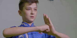 年轻的男孩少年展示传统的问候在功夫握拳