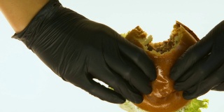 手戴黑手套拿油腻汉堡去品尝，垃圾食品质量把关