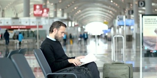 旅客在机场候机室看杂志