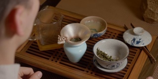 茶师将清水杯倒入碗中，饮用中国茶