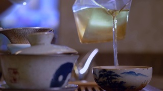 师傅从白碗中倒茶。中国茶道视频素材模板下载