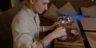 一名男子正在茶盘上准备传统的日本茶