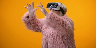 高级女性穿着有趣的外套和VR头盔玩视频游戏，高端创新