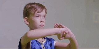 少年男孩的功夫问候双手合在一起，右手拳放在左手掌心是武术中国武术问候。拳头和手掌敬礼。