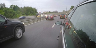 汽车在开始下雨的高峰时间行驶在高速公路上。从车身的侧视图