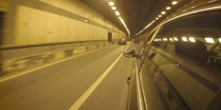 汽车在拥挤的交通中穿过隧道。从车身的侧视图