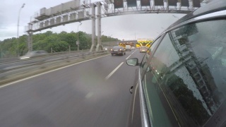 汽车冒着雨开进了隧道。从车身的侧视图视频素材模板下载
