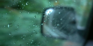 时间流逝水滴在窗户玻璃侧镜汽车背景在下雨。