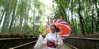 4K吊车拍摄:日本京都岚山和佐野竹林，一名身穿传统和服的亚洲女性乘坐日本人力车——欢迎你来到日本