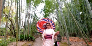 4K吊车拍摄:日本京都岚山和佐野竹林，一名身穿传统和服的亚洲女性乘坐日本人力车——欢迎你来到日本