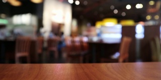 木质台面与餐厅咖啡厅或咖啡厅内部与人抽象散焦模糊背景