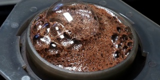 煮沸的水倒在等待开花的空压机中的新鲜磨碎的咖啡豆上