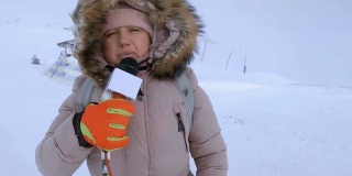天气播报员在冬季山区采访