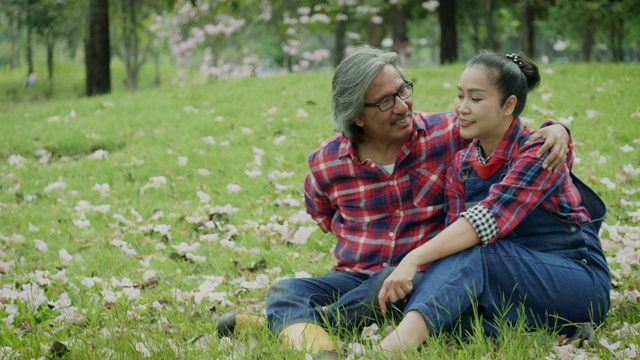 快乐的亚洲成熟夫妇放松和花时间一起在公园户外