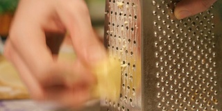 马苏里拉奶酪穿过磨碎的一片奶酪