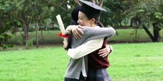 年轻的亚洲女毕业生在毕业典礼上拥抱她的朋友。国际多元化背景