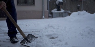一个年长男子铲雪从他的后院的特写
