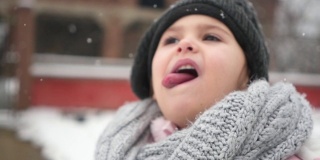 一个年轻女孩用她的舌头捕捉雪花的特写