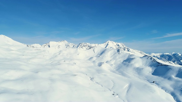 在蓝天下，用无人机飞越雪山。法国的山顶被雪覆盖着。冬天的白色风景令人放松，非常适合极限运动。