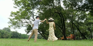 浪漫的亚洲情侣在花园中翩翩起舞。人以生活方式，放松情绪为理念。