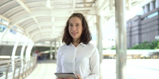 描绘自信的年轻女商人使用数字平板电脑的情景