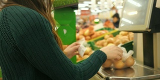 在杂货店里用塑料袋称量土豆的陌生女子