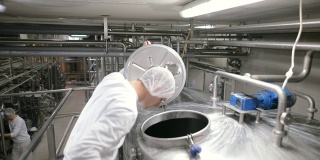 食品厂的工人打开巴氏杀菌罐。乳制品