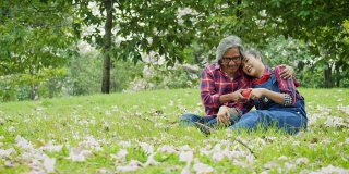快乐的亚洲成熟夫妇放松和花时间一起在公园户外