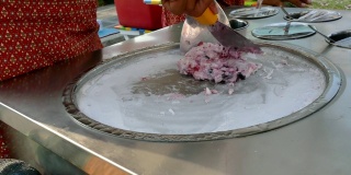 厨师们正在用平底锅制作冰淇淋，平底锅上有冰块
