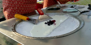 厨师们正在用平底锅制作冰淇淋，平底锅上有冰块