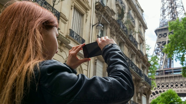 巴黎一名女游客用智能手机拍埃菲尔铁塔