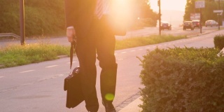 低角度:在日落时分，一个穿西装的男人走在街上。
