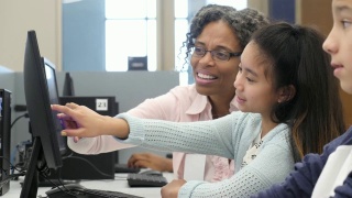 成熟的女家教帮助小学生完成家庭作业视频素材模板下载