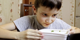 一个十几岁的白人男孩在家里吃中式快餐，用一次性容器装着方便面，他的老鼠很脏