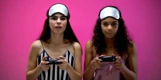 年轻女性穿着睡衣拿着操纵杆玩电子游戏，情绪激动