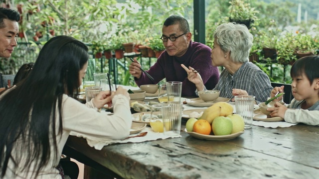 几代同堂的中国家庭在家里享用午餐