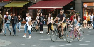 在德国柏林，人们过马路和一些人骑自行车